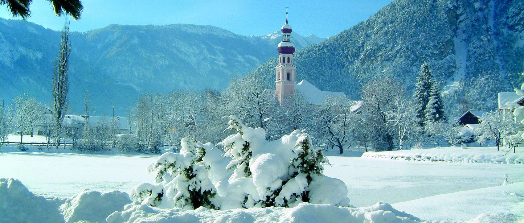 Winterlandschaft, Berge und Kirchturmspitze