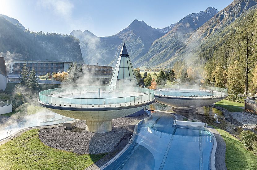 The outdoor area of the Aqua Dome with two floating bowls, surrounded by mountains and a blue sky.