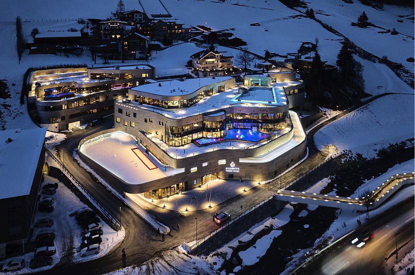 The Silvretta Therme Ischgl building at night surrounded by a snow-covered landscape.