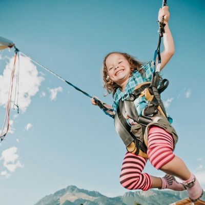 Ein Kind springt auf einem Trampolin.